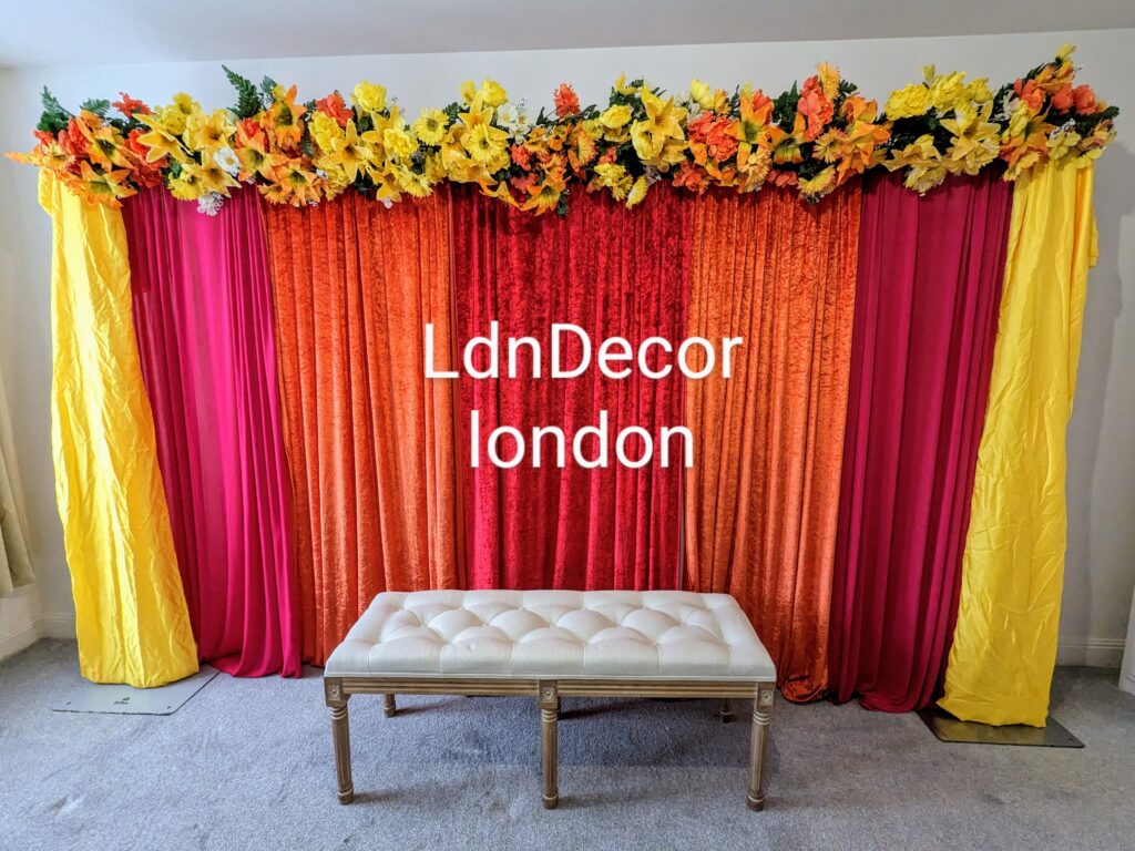 Mehndi yellow orange flower backdrop hire London.